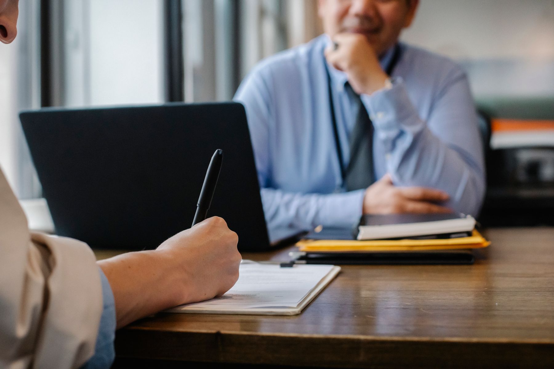 Aantekeningen maken tijdens een gesprek aan een bureau
